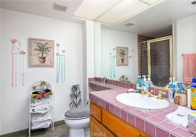 bathroom featuring tile patterned floors, walk in shower, vanity, and toilet