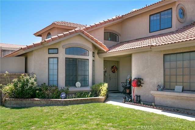 mediterranean / spanish home with a front lawn