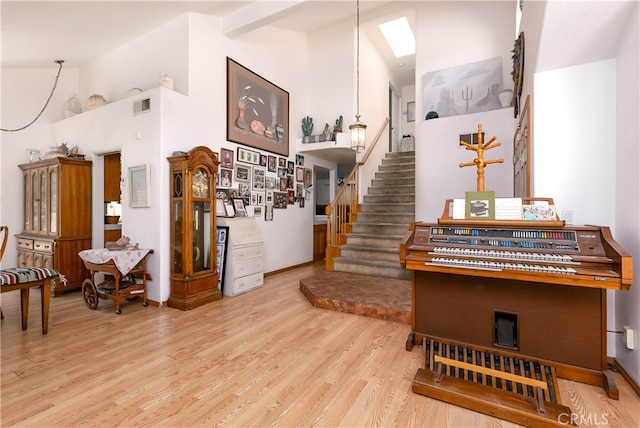 miscellaneous room featuring light hardwood / wood-style floors and high vaulted ceiling