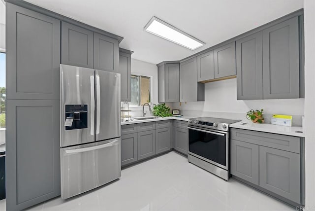 kitchen featuring gray cabinets, appliances with stainless steel finishes, and plenty of natural light