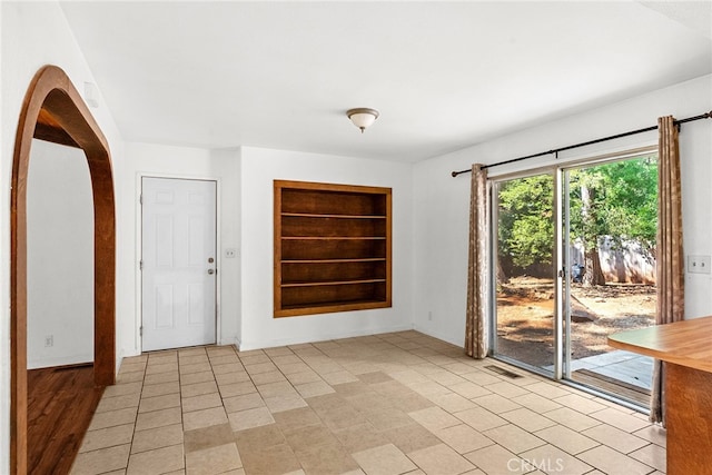 unfurnished room with built in shelves