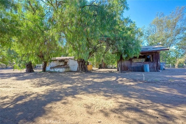 view of yard featuring an outbuilding and dirt driveway