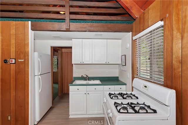 kitchen with beam ceiling, sink, white appliances, light hardwood / wood-style flooring, and white cabinetry