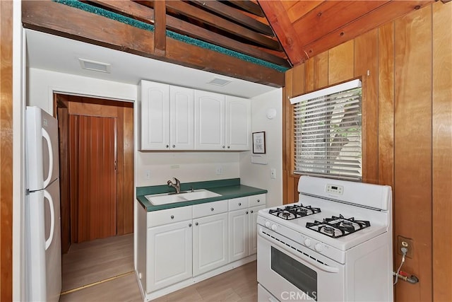 kitchen featuring white cabinetry, a sink, white appliances, and light wood-type flooring