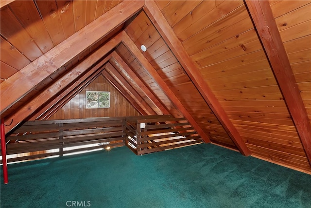 unfinished attic with dark carpet, lofted ceiling, and wooden ceiling