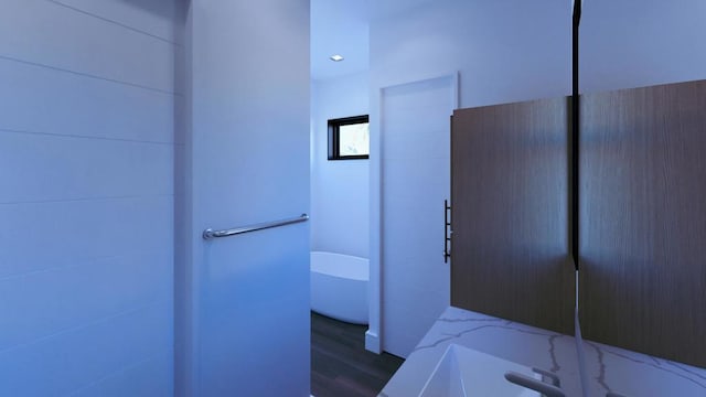 bathroom with wood-type flooring and a bathtub