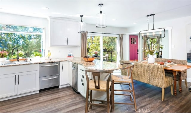 kitchen with white cabinets, sink, and decorative light fixtures