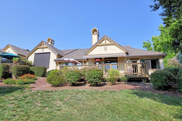 back of house featuring a wooden deck and a lawn