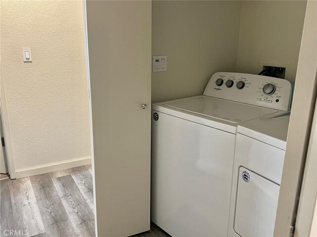 laundry area with light hardwood / wood-style floors and independent washer and dryer