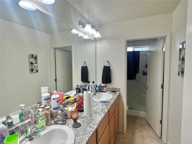 bathroom featuring tile patterned flooring, vanity, and walk in shower