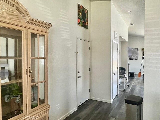 corridor with dark hardwood / wood-style flooring