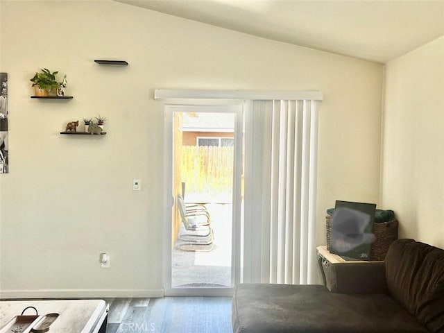 doorway to outside with wood-type flooring and lofted ceiling