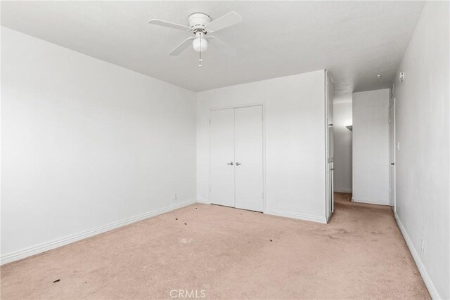 unfurnished bedroom with a closet, ceiling fan, and light colored carpet