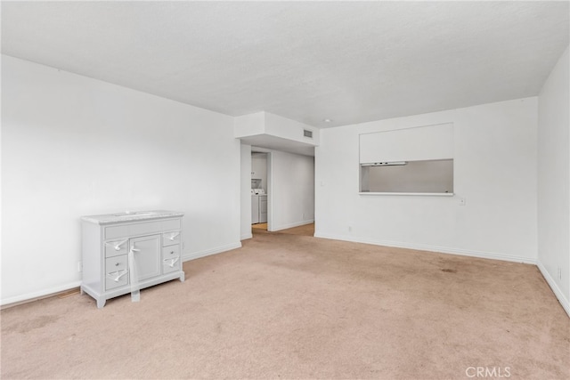 carpeted empty room featuring washing machine and clothes dryer