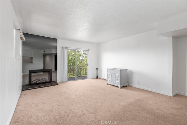 unfurnished living room featuring light colored carpet and a textured ceiling