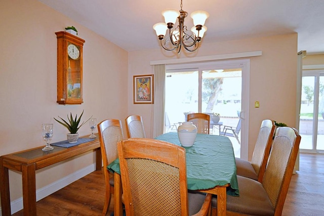 dining room with dark hardwood / wood-style floors and a notable chandelier