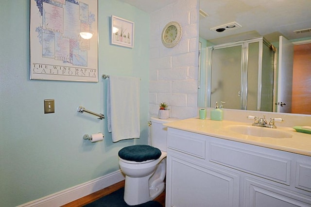 bathroom with vanity, toilet, and a shower with shower door