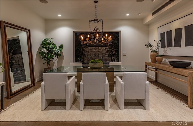 dining area with hardwood / wood-style floors and a chandelier