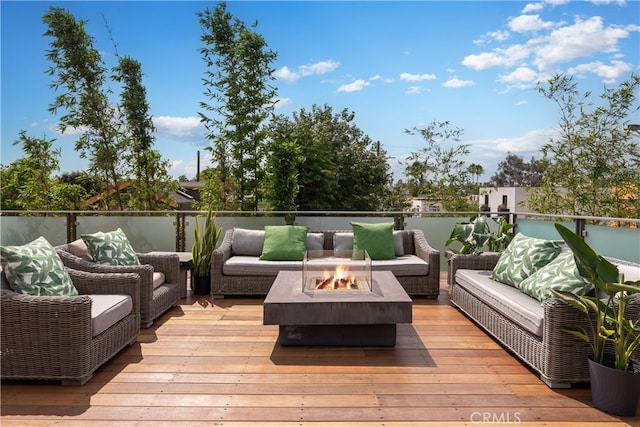 wooden terrace with an outdoor living space with a fire pit