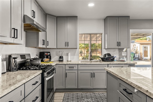 kitchen with gray cabinetry, a wealth of natural light, sink, and stainless steel range with gas stovetop