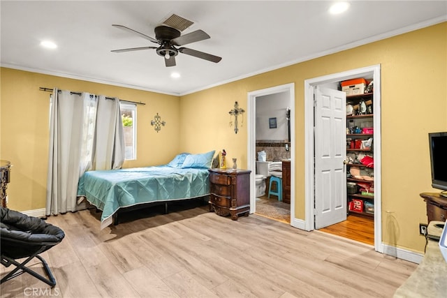 bedroom with light wood-type flooring, ceiling fan, a walk in closet, and a closet