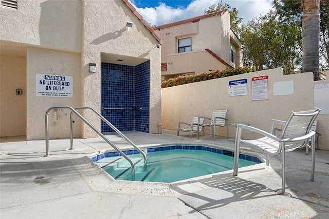 view of swimming pool with a community hot tub and a patio area