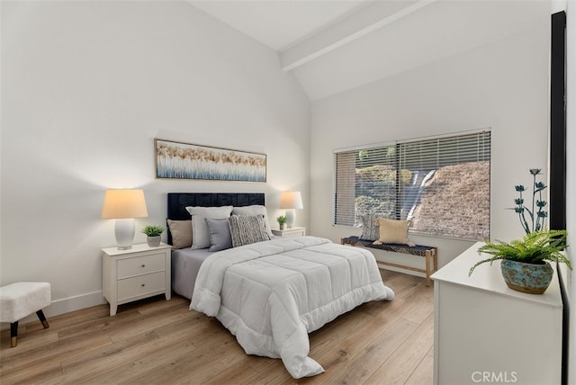 bedroom featuring light wood-type flooring and lofted ceiling with beams