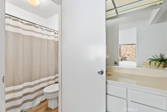 bathroom featuring wood-type flooring, vanity, and toilet