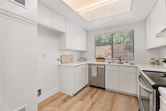 kitchen featuring light wood-type flooring, white cabinetry, appliances with stainless steel finishes, and sink