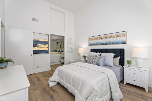 bedroom with wood-type flooring and a high ceiling