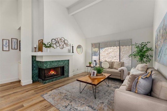 living room with hardwood / wood-style flooring, a fireplace, beam ceiling, and high vaulted ceiling