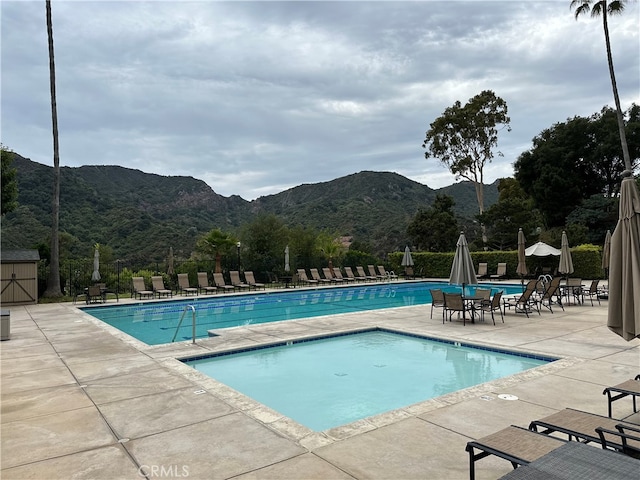 view of swimming pool featuring a patio area and a mountain view