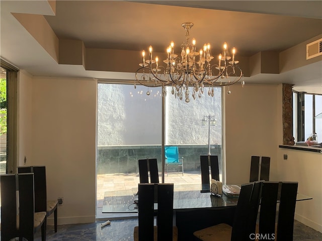 dining room with a healthy amount of sunlight and an inviting chandelier