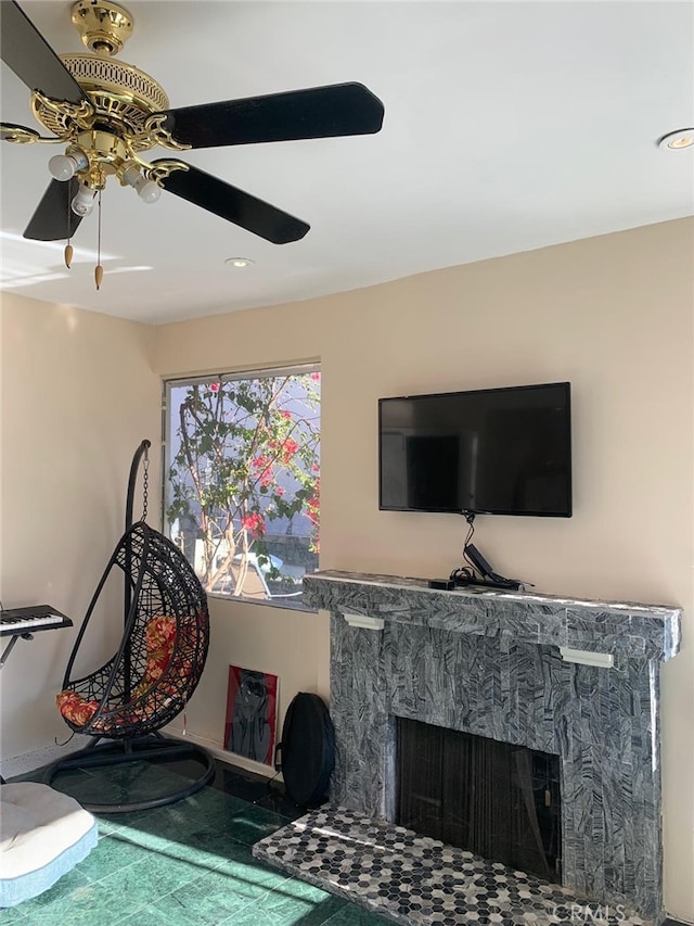 interior space featuring a stone fireplace and ceiling fan