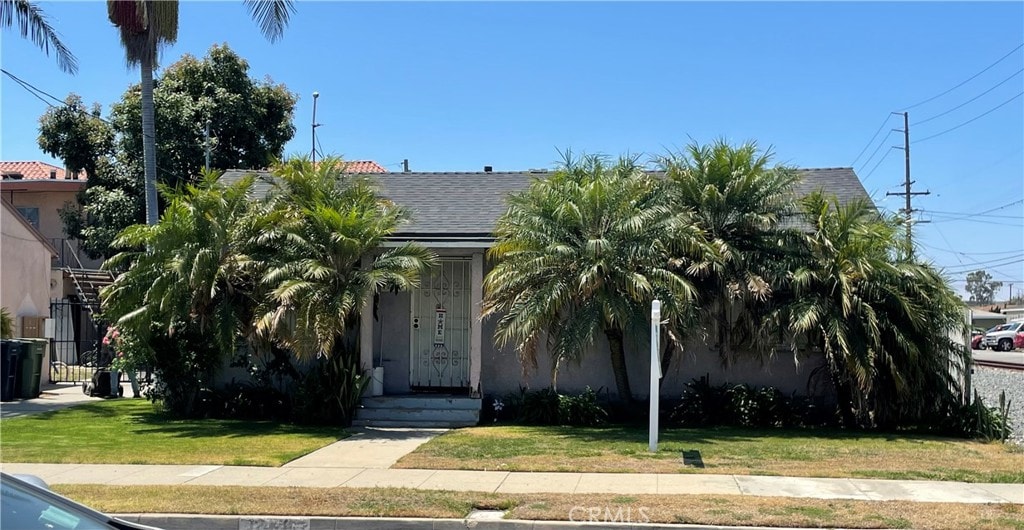 obstructed view of property featuring a front lawn