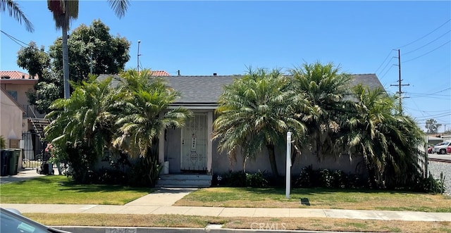 obstructed view of property featuring a front lawn