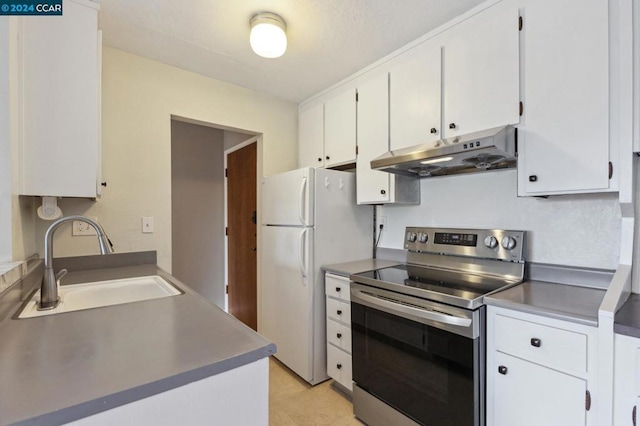 kitchen with white refrigerator, white cabinetry, sink, and electric range