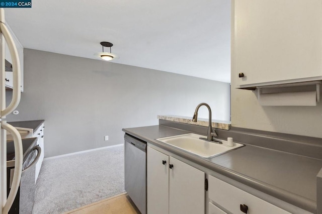 kitchen with light carpet, sink, stainless steel appliances, and white cabinets