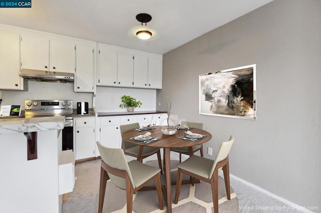 kitchen with electric range and white cabinets