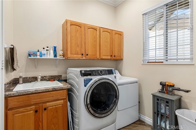 laundry area with cabinets, plenty of natural light, sink, and washing machine and dryer