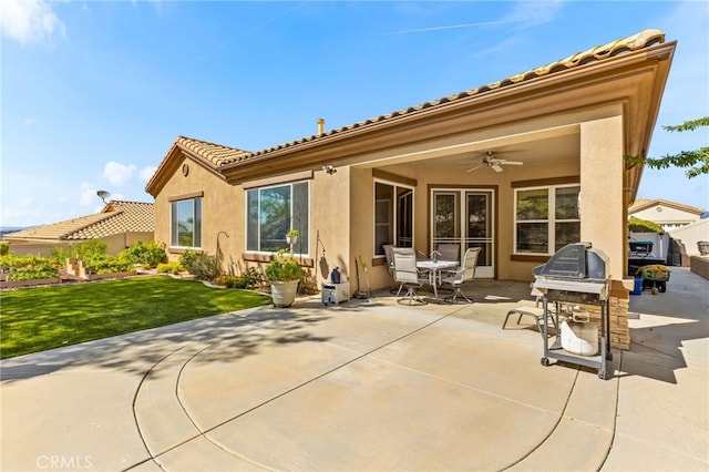 rear view of property with a patio, ceiling fan, and a yard