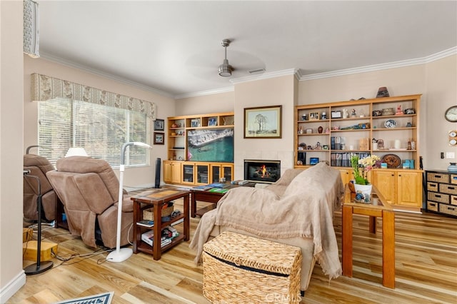 living room featuring light hardwood / wood-style flooring, ceiling fan, and crown molding