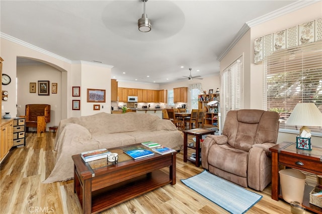 living room featuring light wood-type flooring, ornamental molding, and ceiling fan