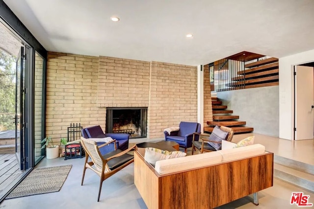 living room with a brick fireplace and brick wall