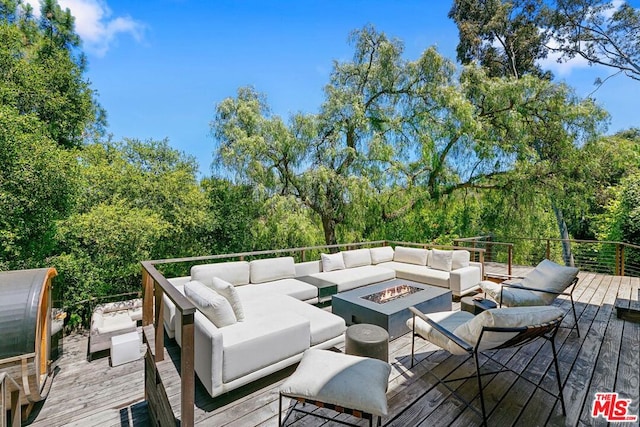 deck featuring an outdoor living space with a fire pit