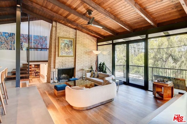 sunroom / solarium featuring lofted ceiling with beams, a brick fireplace, and wood ceiling