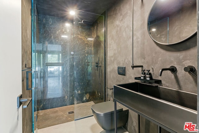 bathroom with tiled shower, vanity, toilet, and tile walls