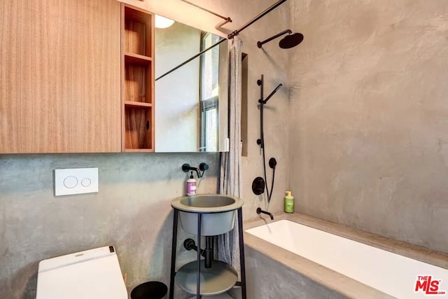 bathroom featuring tiled shower / bath combo and toilet