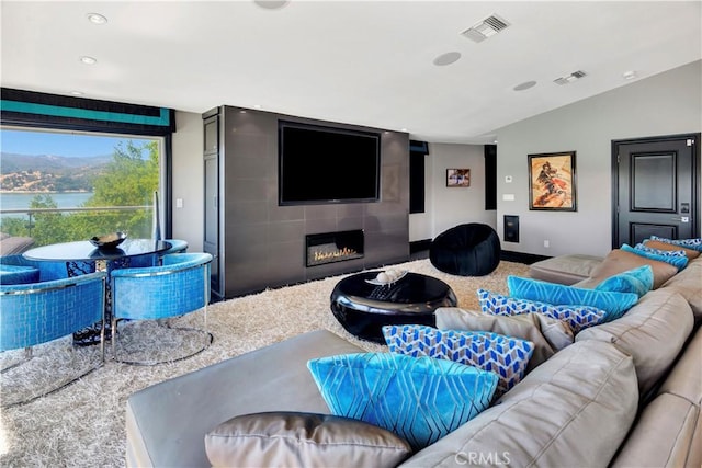 living room featuring a fireplace, carpet, and vaulted ceiling