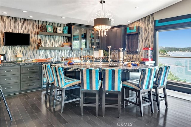 kitchen with a center island, decorative light fixtures, and dark stone countertops